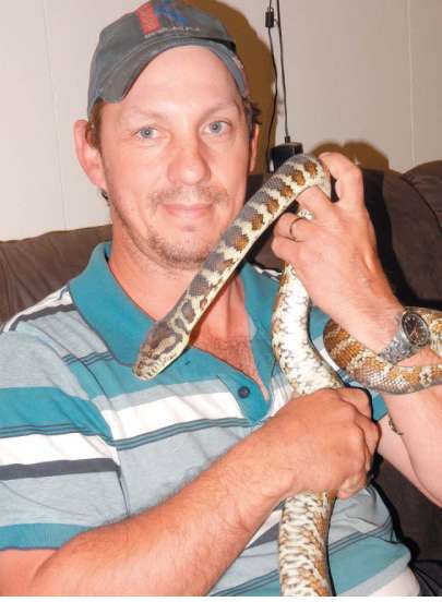 Local python breeder Russell Gardner and one of his beloved pets.